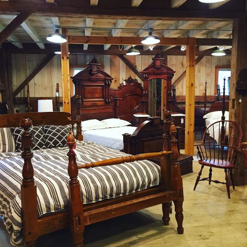 A rustic bedroom with wooden beds, a vintage chair, and exposed beams, creating a cozy, inviting atmosphere.