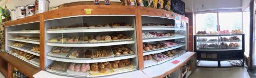 A bakery display case filled with a variety of colorful pastries and baked goods.