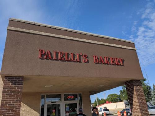 Sign for Paielli's Bakery on a building exterior, with a clear blue sky in the background.