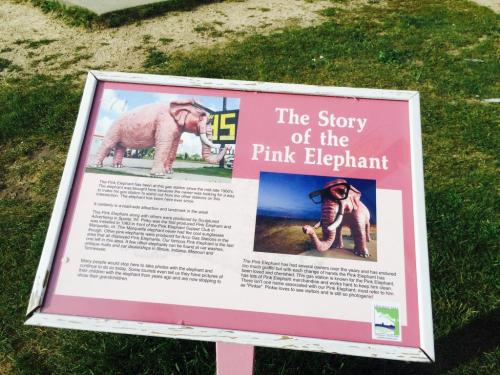 Sign about the Pink Elephant, featuring a large pink elephant statue wearing sunglasses, with a brief history.