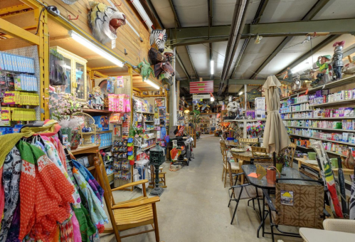 A vibrant store aisle filled with colorful merchandise, decorations, and furniture, creating a lively shopping atmosphere.