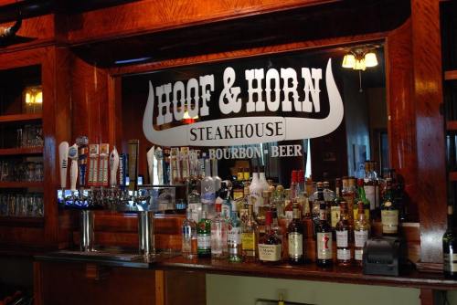 A bar display at Hoof & Horn Steakhouse featuring various liquor bottles and beer taps.