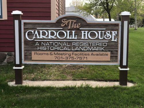Sign for The Carroll House, a national registered historical landmark, with contact information for rooms and meetings.
