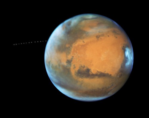 A detailed view of Mars, showcasing its reddish surface and atmospheric features against a black background.