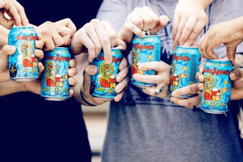 A group of hands holding colorful cans of soda, with a vibrant design featuring cartoon characters.