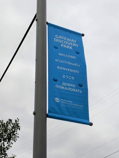 Blue banner for Gateway Discovery Park with multilingual welcome messages.