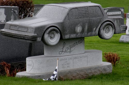 A unique gravestone shaped like a car, featuring the name "Laguerrero" and dates of birth and death.