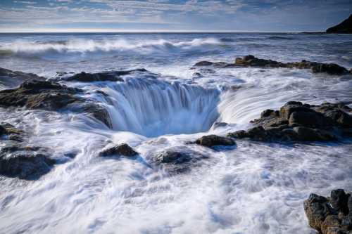 A dramatic ocean scene featuring a swirling water vortex surrounded by rocky shorelines and gentle waves.