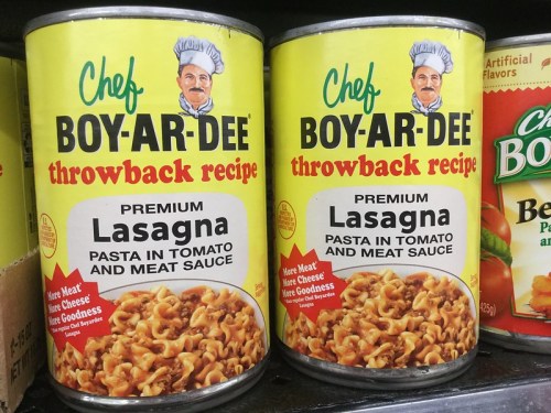 Two cans of Chef Boy-Ar-Dee Lasagna, featuring a bright yellow label with a chef's image and the text "throwback recipe."