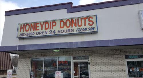 Sign for Honeydip Donuts, open 24 hours, with a welcoming "Open" sign in the window.