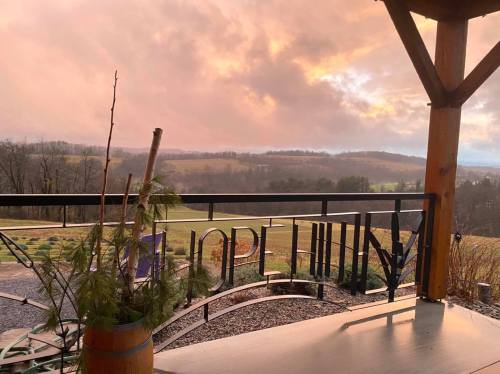 A scenic view of rolling hills at sunset, framed by a wooden porch railing with the word "HOPE" visible.