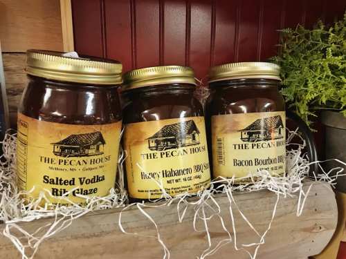 Three jars of gourmet sauces labeled "Salted Vodka Rib Glaze," "Honey Habanero BBQ," and "Bacon Bourbon BBQ" on display.