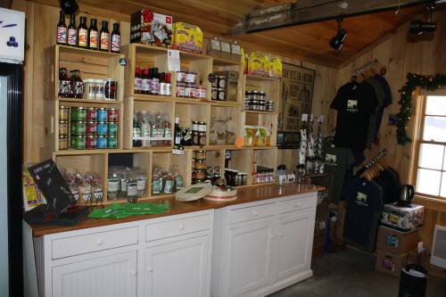 A cozy shop interior with wooden shelves displaying various food products, jars, and merchandise.