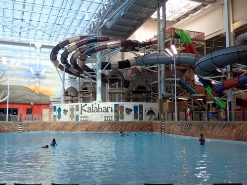 Indoor water park featuring a large pool, water slides, and playful guests enjoying the attractions.