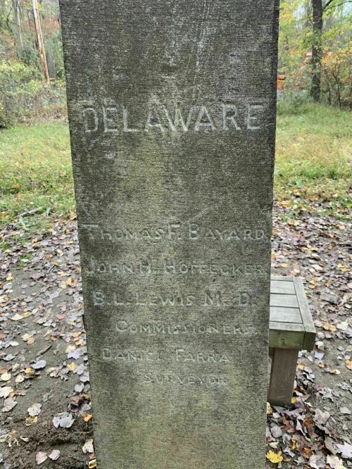Stone monument with the word "DELAWARE" and names of commissioners Thomas F. Bayard, John H. Hoffecker, S.L. Lewis, and D. Farra.