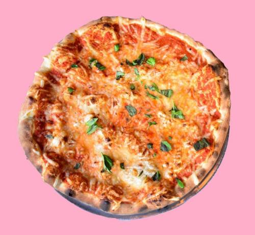 A freshly baked pizza topped with melted cheese and fresh basil on a pink background.