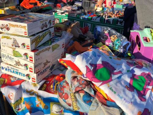 A colorful assortment of toys, games, and blankets displayed at a market, featuring popular characters and themes.