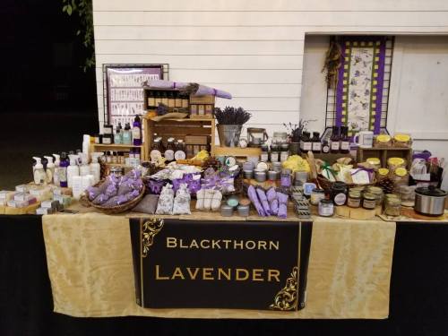 A display table featuring various lavender products, including soaps, lotions, and dried lavender, with a decorative sign.