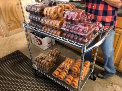 A cart filled with various packaged donuts in different flavors, displayed in a kitchen setting.