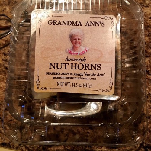 Container of Grandma Ann's homestyle Nut Horns, featuring a smiling woman on the label. Net weight: 14.5 oz.