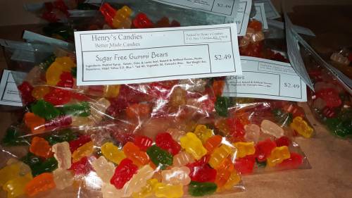 A pile of colorful gummy bears in clear bags, labeled "Sugar Free Gummy Bears" with a price tag of $2.49.