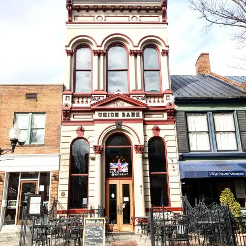 Historic Union Bank building with red accents, featuring a restaurant sign and outdoor seating area.