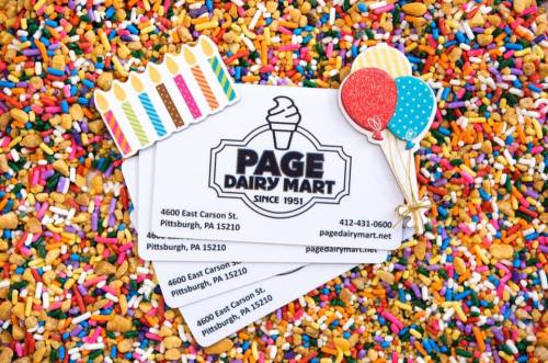 Business cards for Page Dairy Mart on a colorful background of sprinkles and candy, featuring birthday candles and balloons.