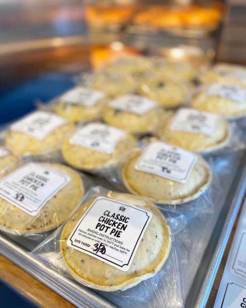 A tray of individually packaged classic chicken pot pies with labels, ready for sale.