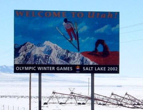 Billboard welcoming visitors to Utah, featuring skiing and mountains, promoting the Salt Lake 2002 Olympic Winter Games.
