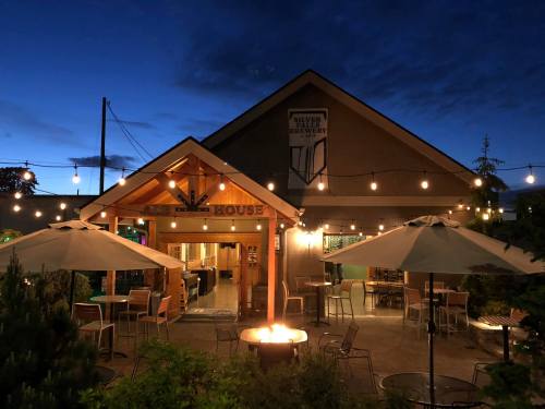 A cozy restaurant exterior at night, with string lights, outdoor seating, and a warm inviting atmosphere.