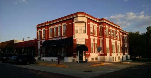 Historic red brick building with white trim, featuring large windows and a sign for "Hotel Josephine."