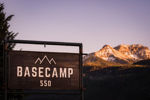 Sign for Basecamp 550 with mountains in the background during sunset.