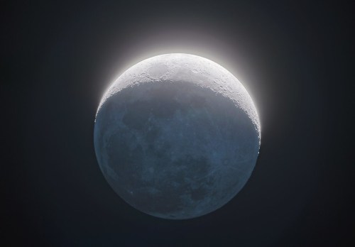 A crescent moon illuminated against a dark sky, showcasing its craters and surface details.