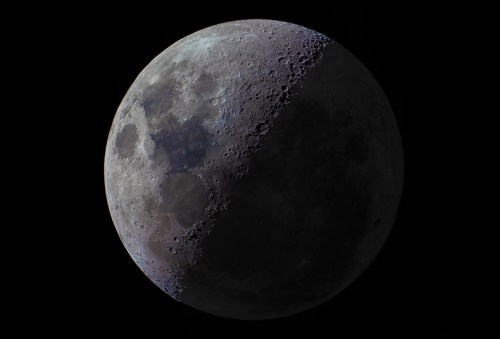 A detailed view of a crescent moon, showcasing craters and surface textures against a dark background.