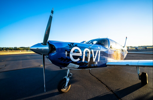 A blue aircraft with "envi" on its side parked on a runway under a clear sky.