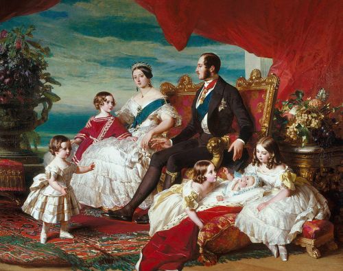 A royal family portrait featuring a couple and their children, seated on an ornate couch with a colorful background.