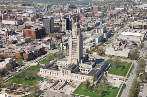 Aerial view of a city skyline featuring a prominent government building with a golden dome surrounded by urban structures.