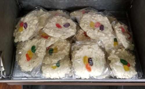 A metal container filled with individually wrapped rice crispy treats topped with jelly beans.
