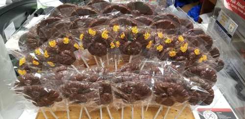 A display of chocolate turkey-shaped lollipops, each wrapped in clear plastic with colorful sprinkles on top.