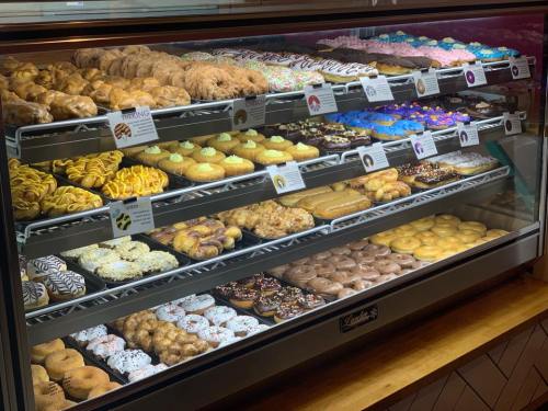 A display case filled with a variety of colorful donuts and pastries, showcasing an assortment of sweet treats.