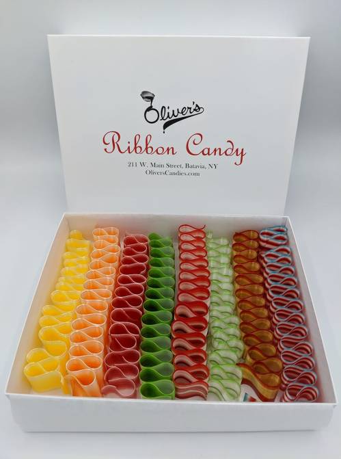 A box of colorful ribbon candy in various shades, neatly arranged in rows, with the brand name "Oliver's" on the lid.