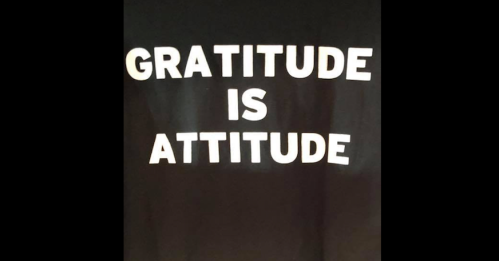 Black shirt with bold white text that reads "GRATITUDE IS ATTITUDE."