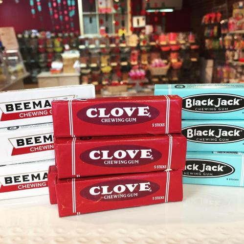 A display of various chewing gum packs, including Clove, Beeman's, and Black Jack, in a colorful store setting.