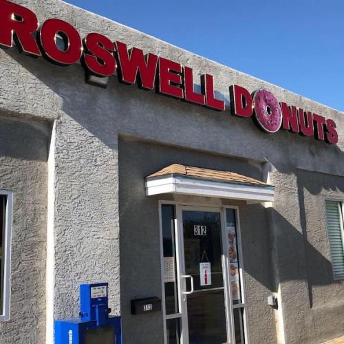 Exterior of Roswell Donuts shop with a clear blue sky in the background.