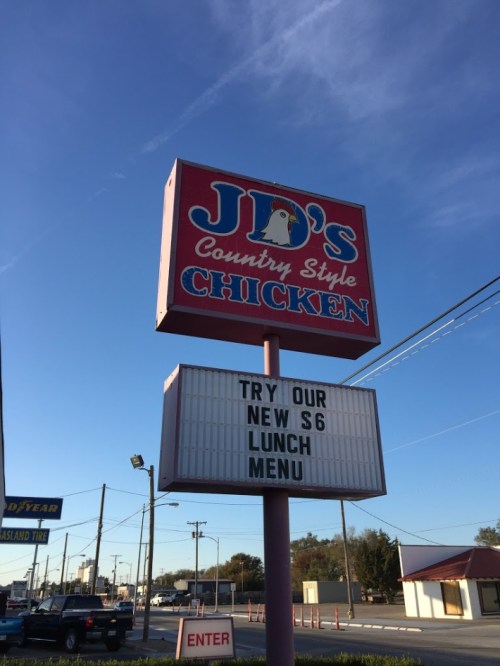 Sign for JD's Country Style Chicken advertising a new $6 lunch menu against a clear blue sky.