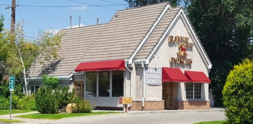 A charming donut shop with a sloped roof, red awnings, and a sign that reads "Award Winning Donuts."