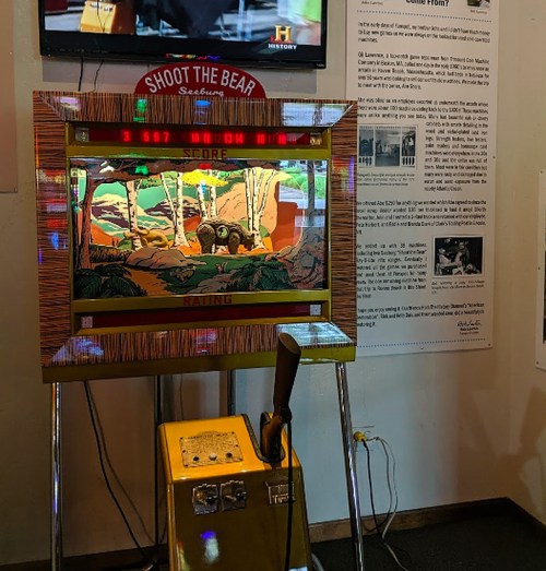 A vintage arcade game titled "Shoot the Bear," featuring a colorful forest scene and a score display.