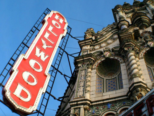 Historic Hollywood sign against a blue sky, featuring ornate architectural details on the building.