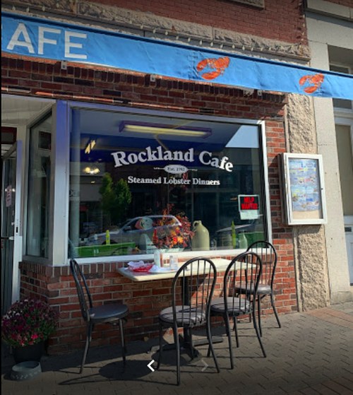 Exterior of Rockland Cafe with a blue awning, a window display, and outdoor seating for diners.