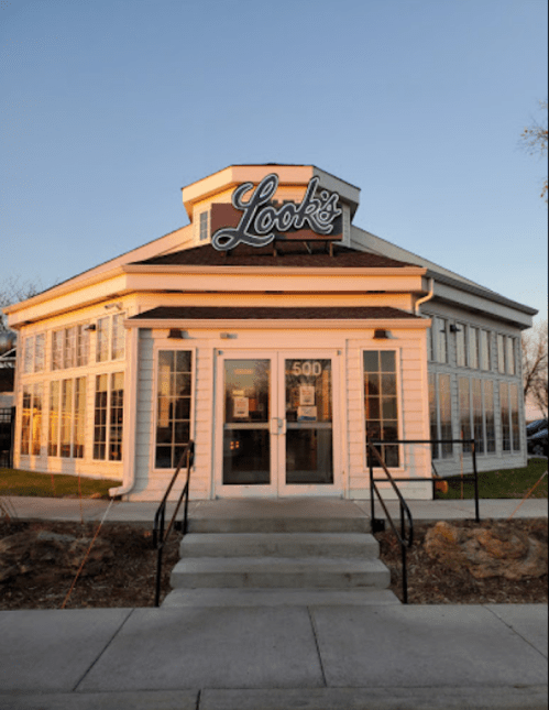 A modern restaurant with large windows and a sign reading "Look's," set against a clear sky at sunset.